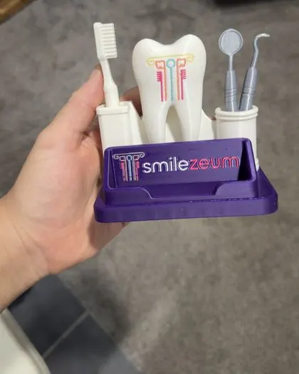 The custom 3D printed dental business card holder held in a hand