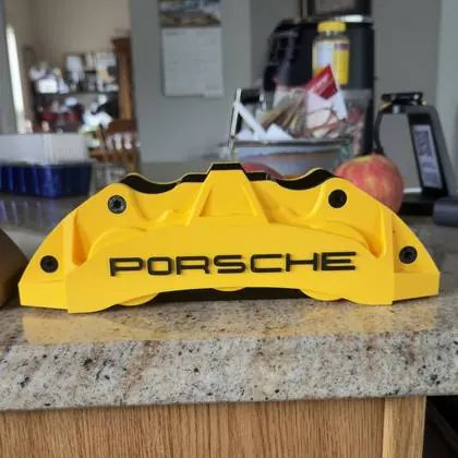 The yellow 3D printed caliper pen holder on a counter